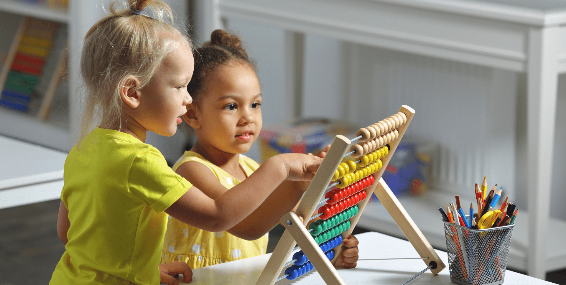 Two young children playing with an abacus.